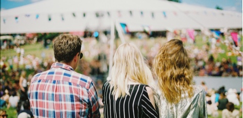 Three people with their backs to the camera looking at the festivities at a special event they're attending.