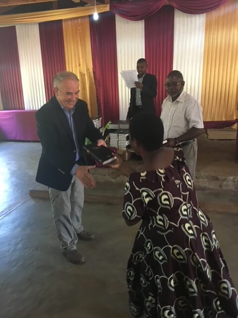 Jim Robertson presenting a Bible to a person in Malawi.