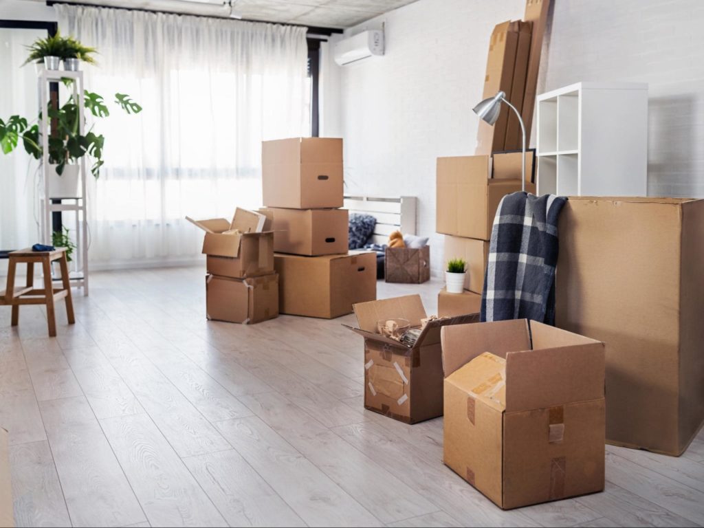 A picture of an apartment with a modern aesthetic with moving boxes scattered across the floor.