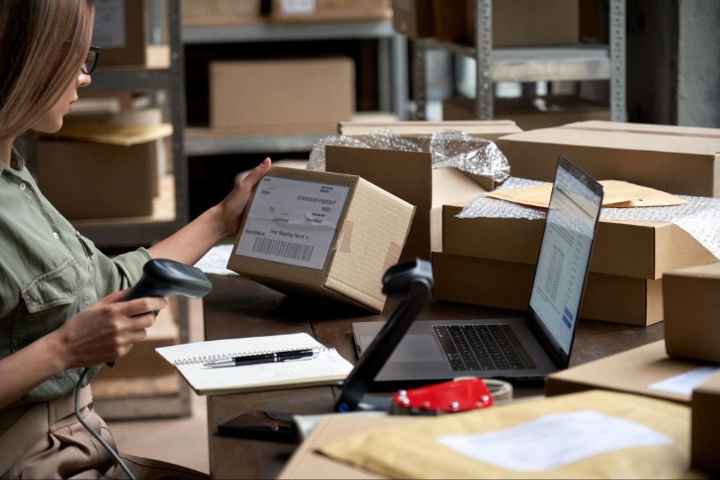 Ecommerce professional scanning packages in a warehouse.